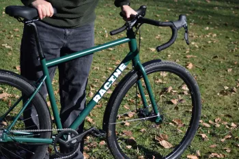 Vélo urbain Vélos-Racine cadre acier CrMo vert mouche, cintre drop bar, vue de trois-quarts avec cycliste