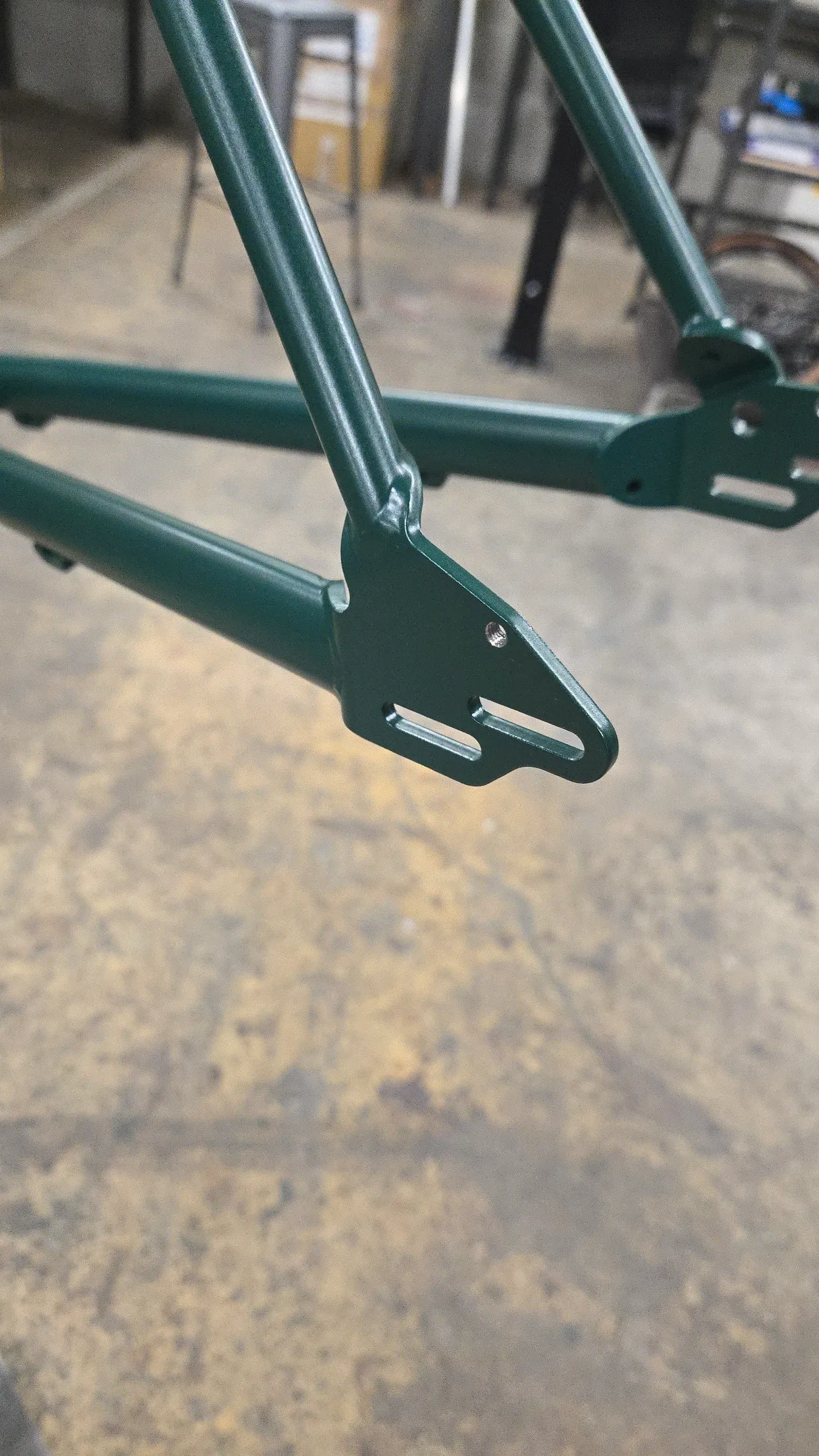 Détail de base arrières réglables de cadre en acier chromoly vert mousse, atelier de fabrication